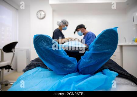 Il chirurgo sutura la palpebra dopo un intervento di chirurgia plastica Foto Stock