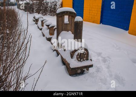 Paesaggio invernale nella città di Braunschweig, Germania. Treno per bambini coperto di neve. Stagione invernale con nevicate pesanti Foto Stock