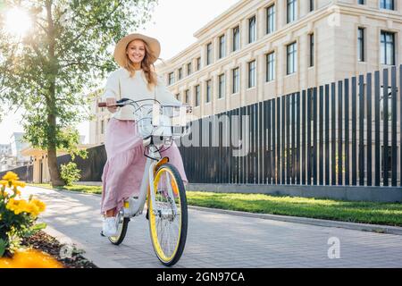 Donna sorridente in bicicletta sul sentiero Foto Stock