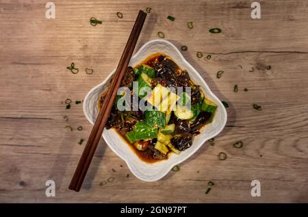 Insalata tradizionale cinese di cetrioli alle alghe servita con bacchette Foto Stock