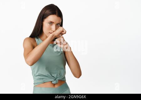 Pugilato sportivo sicuro, lotta, allenamento in palestra, abbigliamento sportivo su sfondo bianco Foto Stock