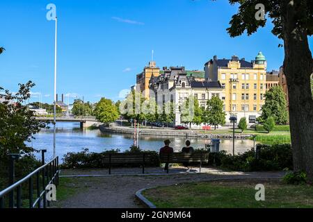 Due persone irriconoscibili ammirano la vista della città di Norrkoping e del fiume Motala al Refparens grund in una giornata di sole nel mese di agosto. Foto Stock