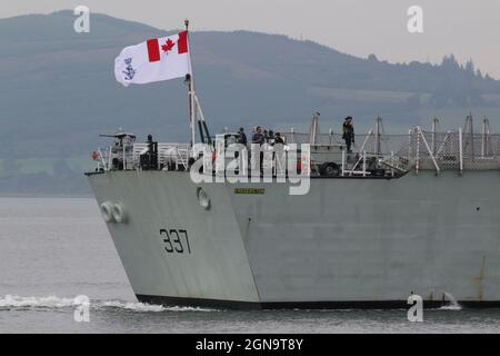 Alcuni membri dell'equipaggio si riuniscono vicino all'insegna della Royal Canadian Navy, volando dall'HMCS Fredericton (FFH-337), una fregata di classe Halifax (o City-Class). La nave è visto passare Greenock sul Firth di Clyde, prima di partecipare agli esercizi militari Dynamic Mariner 2021 e Joint Warrior 21-2. Foto Stock