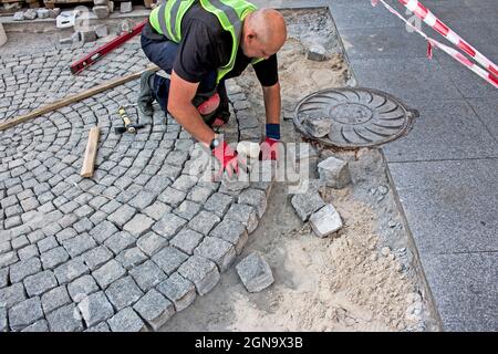 Dnepropetrovsk, Ucraina - 09.17.2021: Produzione di calcestruzzo e posa di pietre di pavimentazione - finitura esterna della zona vicino alla casa - sostituzione di asfalto Foto Stock