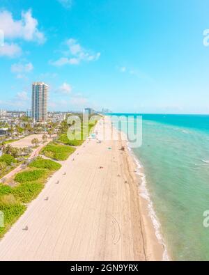 Bella Miami Beach in una mattinata di sole con spiaggia di sabbia bianca, acqua blu e verde dietro la spiaggia Foto Stock