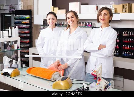 Ritratto di manicuristi professionisti al posto di lavoro invitando al salone Foto Stock