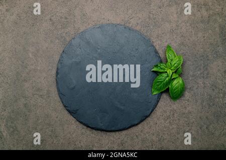 Piatto di pizza vuoto per cottura fatta in casa su cemento scuro. Concetto di ricetta alimentare su sfondo di pietra scura con spazio di copia. Foto Stock