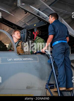 Un pilota assegnato al 44o Fighter Squadron e un manutentore del diciottesimo Squadron di manutenzione dell'aeromobile si preparano ad avviare un'aquila F-15C prima di una missione di addestramento di volo notturno alla base aerea di Kadena, Giappone, 22 settembre 2021. Fiducia e lavoro di squadra tra operazioni e manutenzione gli Airmen sono fondamentali per qualsiasi missione di volo di successo. (STATI UNITI Air Force foto di Maj. Raymond Geoffroy) Foto Stock