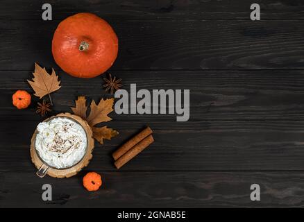 Latte di zucca speziata con crema espansa, bastone di cannella, foglia e ingredienti Foto Stock