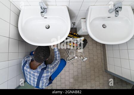 Tubo di fissaggio idraulico in bagno. Manutenzione dell'impianto idraulico in bagno Foto Stock