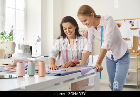 Due velati marinai che lavorano con tessuti e disegni nel loro atelier da cucire Foto Stock