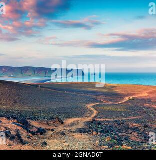 Splendido tramonto estivo sulla spiaggia di Kirkjufjara. Colorata vista serale delle scogliere di Reynisdrangar dalla penisola di Dyrholaey nell'oceano Atlantico. Sud Icel Foto Stock