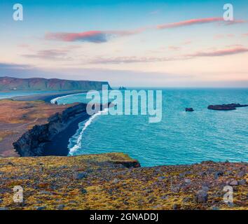 Colorato tramonto estivo sulla spiaggia di Kirkjufjara. Vista serale delle scogliere di Reynisdrangar dalla penisola di Dyrholaey nell'oceano Atlantico. Islanda meridionale, Vic v Foto Stock