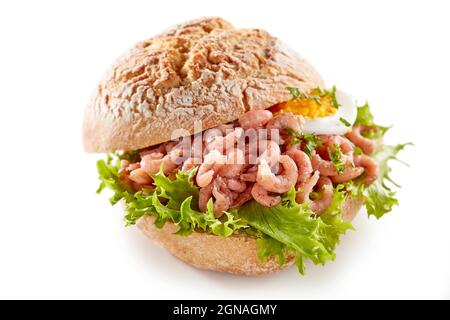 Alto angolo di delizioso panino con gamberi e lattuga posti sul tavolo bianco in studio Foto Stock