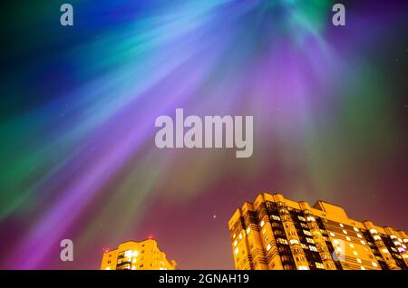 Aurora borealis notte stellata sulla città e le case. Foto Stock