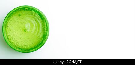 Gel cosmetico in vaso su sfondo bianco. Gel trasparente verde con consistenza e bolle isolano. Foto di alta qualità Foto Stock