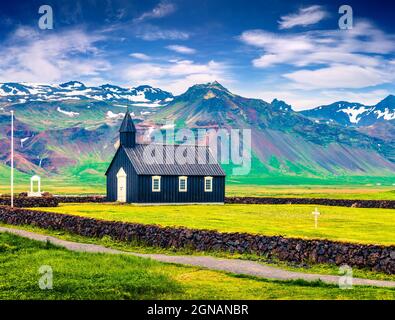 Chiesa di Budakirkja in legno nero a Saefellsnes. Drammatica mattinata estiva con campo di erba verde fresca sulla penisola di Snafellsnes, Islanda occidentale, Euro Foto Stock