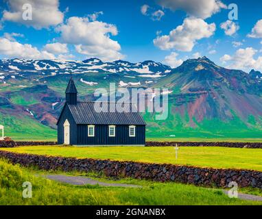 Chiesa di Budakirkja in legno nero a Saefellsnes. Drammatica mattinata estiva con campo di erba verde fresca sulla penisola di Snafellsnes, Islanda occidentale, Euro Foto Stock