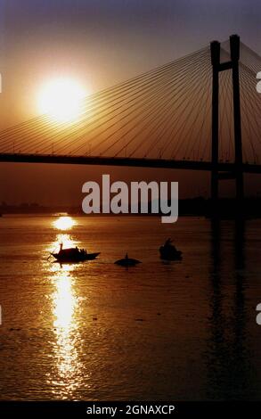 Il sole si trova dietro Vidyasagar Setu o il secondo ponte Hooghly (Ponte nuovo), Calcutta Kolkata, Bengala Occidentale, India. Foto di Sondeep Shankar Foto Stock