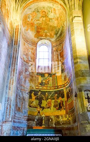 Affresco romanico nell'abside settentrionale raffigurante la crocifissione di San Pietro e la decapitazione di San Paolo. La più grande serie di mura figurativa della Svizzera Foto Stock