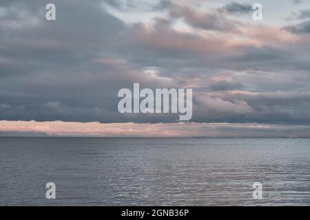 Bellissimo cielo nuvoloso e suggestivo sulla baia al tramonto Foto Stock