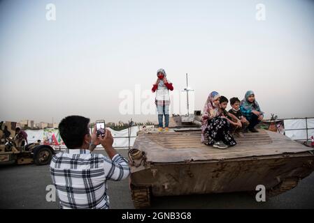 Teheran, Iran. 23 settembre 2021. Ragazzi e ragazze si posano con un carro armato militare mentre visitano una mostra di guerra che è tenuta e organizzata dal corpo di Guardia rivoluzionaria Islamica (IRGC) in un parco nel sud di Teheran per celebrare l'anniversario della guerra Iran-Iraq (1980-88) il 23 settembre 2021. (Foto di Sobhan Farajvan/Pacific Press) Credit: Pacific Press Media Production Corp./Alamy Live News Foto Stock