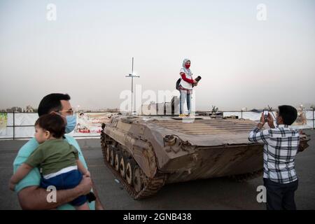 Teheran, Iran. 23 settembre 2021. Una giovane ragazza posa con un carro armato militare mentre visita una mostra di guerra che si tiene e organizzato dal corpo di Guardia rivoluzionaria Islamica (IRGC) in un parco nel sud di Teheran per celebrare l'anniversario della guerra Iran-Iraq (1980-88) il 23 settembre 2021. (Foto di Sobhan Farajvan/Pacific Press) Credit: Pacific Press Media Production Corp./Alamy Live News Foto Stock