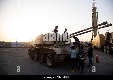 Teheran, Iran. 23 settembre 2021. I ragazzi si trovano su un carro armato militare in una mostra di guerra organizzata dal corpo di Guardia rivoluzionaria Islamica (IRGC) in un parco nel sud di Teheran per celebrare l'anniversario della guerra Iran-Iraq (1980-88) il 23 settembre 2021. (Foto di Sobhan Farajvan/Pacific Press) Credit: Pacific Press Media Production Corp./Alamy Live News Foto Stock