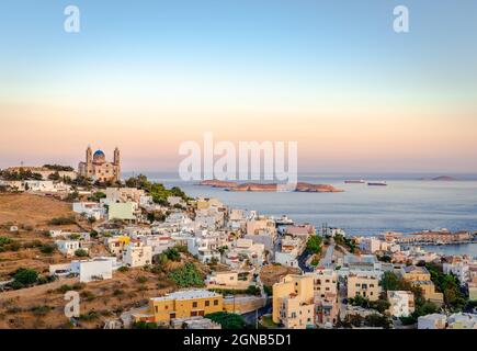 Tramonto panoramico a Ermoupolis, la capitale delle Cicladi, Grecia, con la chiesa di San Nicola sulla sinistra e il Mar Egeo sullo sfondo. Foto t Foto Stock