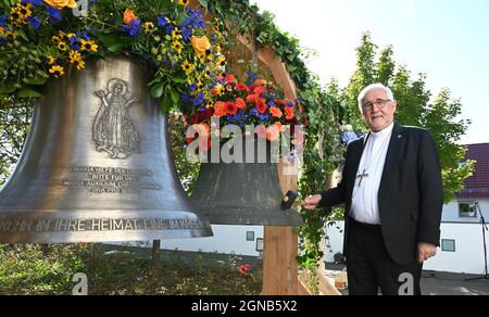 Aichtal, Germania. 24 settembre 2021. Il vescovo Gebhard Fürst si trova di fronte alla chiesa 'mia Hilf der Christen' di fronte ad una campana della chiesa (r) che deve essere restituita ad una parrocchia nella Repubblica Ceca e ad una nuova campana. La diocesi sta lanciando il progetto di pace cattolico finora unico, "Peace Bells for Europe", ritornando nelle parrocchie polacche e ceche campane che un tempo furono tolse dal regime nazista nei cosiddetti territori orientali tedeschi e che dovevano essere date alla macchina da guerra. Credit: Bernd Weißbrod/dpa/Alamy Live News Foto Stock