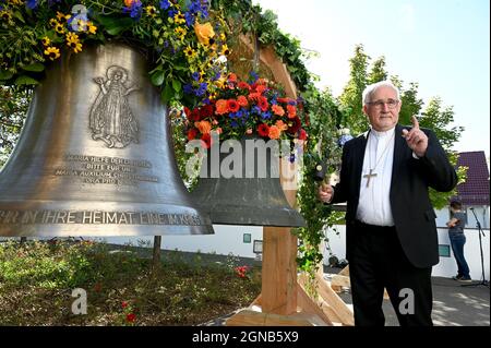 Aichtal, Germania. 24 settembre 2021. Il vescovo Gebhard Fürst si trova di fronte alla chiesa 'mia Hilf der Christen' di fronte ad una campana della chiesa (r) che deve essere restituita ad una parrocchia nella Repubblica Ceca e ad una nuova campana. La diocesi sta lanciando il progetto di pace cattolico finora unico, "Peace Bells for Europe", ritornando nelle parrocchie polacche e ceche campane che un tempo furono tolse dal regime nazista nei cosiddetti territori orientali tedeschi e che dovevano essere date alla macchina da guerra. Credit: Bernd Weißbrod/dpa/Alamy Live News Foto Stock