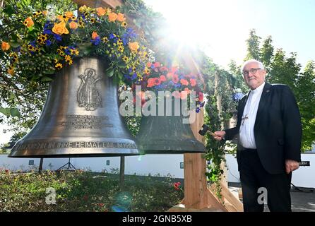 Aichtal, Germania. 24 settembre 2021. Il vescovo Gebhard Fürst si trova di fronte alla chiesa 'mia Hilf der Christen' di fronte ad una campana della chiesa (r) che deve essere restituita ad una parrocchia nella Repubblica Ceca e ad una nuova campana. La diocesi sta lanciando il progetto di pace cattolico finora unico, "Peace Bells for Europe", ritornando nelle parrocchie polacche e ceche campane che un tempo furono tolse dal regime nazista nei cosiddetti territori orientali tedeschi e che dovevano essere date alla macchina da guerra. Credit: Bernd Weißbrod/dpa/Alamy Live News Foto Stock