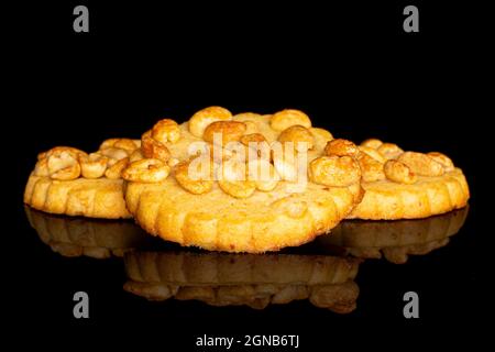 Gruppo di tre biscotti interi e deliziosi con arachidi su vetro nero Foto Stock