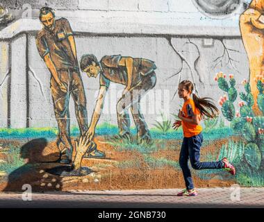 Città di Gaza, striscia di Gaza, Palestina. 23 settembre 2021. Gaza, Palestina. 23 settembre 2021. I palestinesi camminano vicino a un murale raffigurante i 6 prigionieri palestinesi fuggiti dalla prigione di Gilboa il 6 settembre 2021. Anche se Israele ha catturato tutti e sei i prigionieri palestinesi fuggiti dalla prigione di massima sicurezza israeliana, i palestinesi hanno salutato i fuggitivi come eroi nella loro lotta contro l'occupazione israeliana (immagine di credito: © Ahmad Hasaballah/IMAGESLIVE via ZUMA Press Wire) Foto Stock