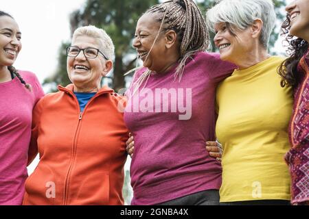 Happy donne multi generazionali che hanno divertimento abbracciando insieme dopo lo sport workout - fuoco principale sul volto africano della donna Foto Stock