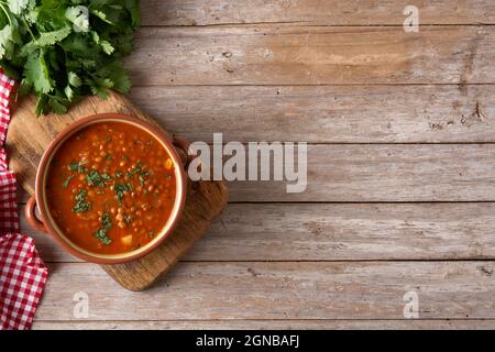 Zuppa di lenticchie rosse in ciotola su un rustico tavolo di legno Foto Stock