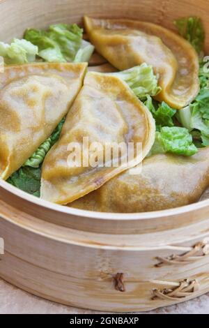 Streaming gyoza (Jiaozi) in bamboo cestello per la cottura a vapore Foto Stock