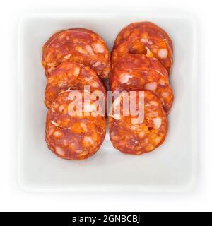Primo piano di salame di chorizo paprika in una ciotola bianca isolata su sfondo bianco Foto Stock