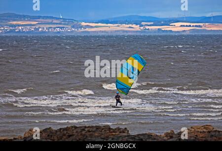 Longniddry, East Lothian, Scozia, tempo britannico. 24 settembre 2021. Buon vento per Kitesurfing anche se molto blustery a W 44 km/h con raffiche 75 km/h sul Firth of Forth. Temperatura 18 gradi centigradi. Nella foto: Un appassionato di sport acquatici coraggiosi sfidare le condizioni difficili. Credit: Arch White/Alamy Live News. Foto Stock