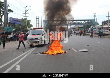 Non esclusiva: NARAYANGANJ, BANGLADESH - 23 SETTEMBRE 2021: I lavoratori dell'abbigliamento hanno acceso il fuoco nel mezzo della strada autostradale di Dhaka-Chittagong, durante le rivolte Foto Stock