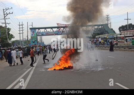 Non esclusiva: NARAYANGANJ, BANGLADESH - 23 SETTEMBRE 2021: I lavoratori dell'abbigliamento hanno acceso il fuoco nel mezzo della strada autostradale di Dhaka-Chittagong, durante le rivolte Foto Stock