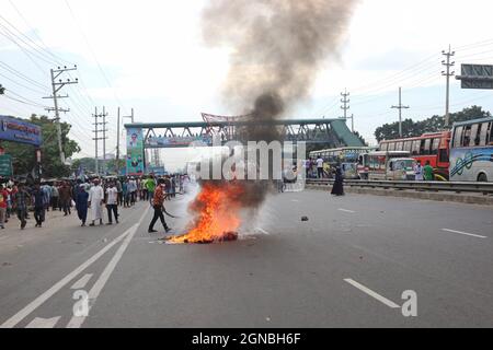 Non esclusiva: NARAYANGANJ, BANGLADESH - 23 SETTEMBRE 2021: I lavoratori dell'abbigliamento hanno acceso il fuoco nel mezzo della strada autostradale di Dhaka-Chittagong, durante le rivolte Foto Stock