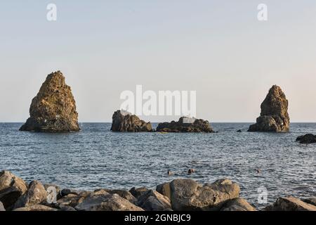 I Faraglioni, un gruppo di basalto vulcanico si stacca ad Aci Trezza (Acitrezza), Sicilia, Italia. Conosciuta anche come Isole Ciclopi Foto Stock