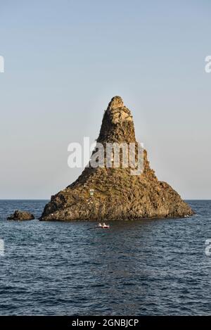 Il Faraglione Grande, uno dei Faraglioni o delle Isole dei Ciclopi, un gruppo di basalti vulcanici al largo di Aci Trezza, Sicilia, Italia Foto Stock