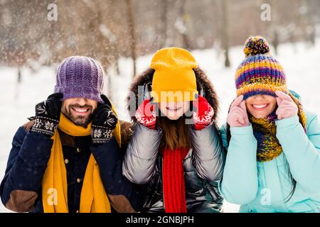 Foto di famiglia allegro felice sorriso positivo hanno divertimento divertente imbrogliare vicino coprire occhi cappello all'aperto Foto Stock