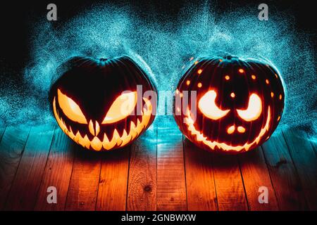 zucche di halloween su tavole di legno con luci led astratte sullo sfondo. Foto Stock