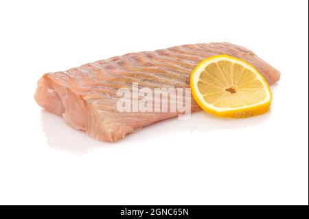 Primo piano di lombo di pesce crudo con una fetta di limone su sfondo bianco Foto Stock