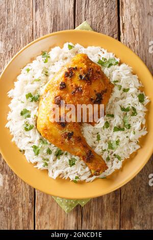 Pollo speziato alla malese Ayam Percik arrosto con riso in primo piano nel piatto. Vista dall'alto verticale Foto Stock