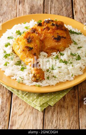 Ayam Percik Coconut Spiced Chicken con riso in primo piano nel piatto sul tavolo. Verticale Foto Stock