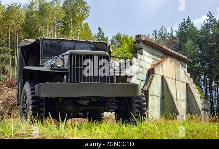 Una storica auto off-Road dell'esercito statunitense si trova di fronte a un ex aeroporto militare. Foto Stock